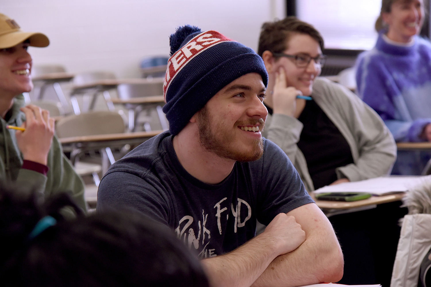 A smiling student sitting in a geospatial technology class