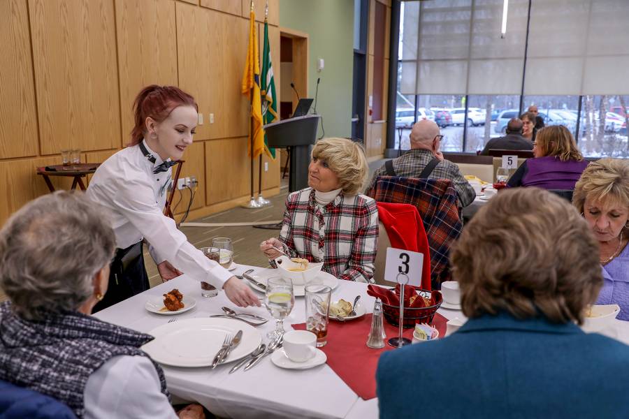 hospitality student waiting on customer in dining room