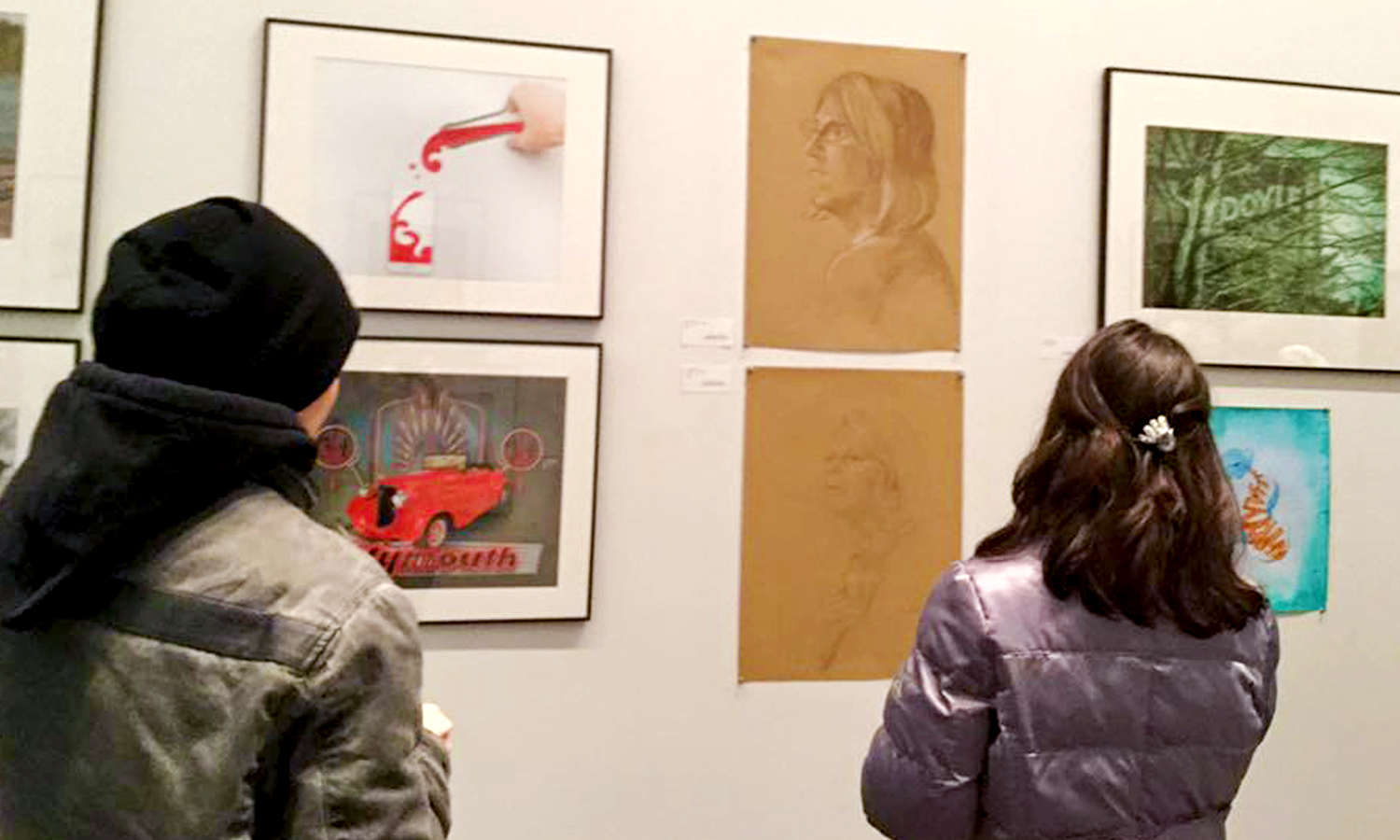 Two people looking at artwork in the gallery