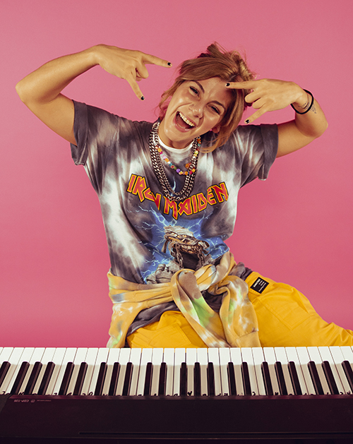 singer-songwriter Jax with keyboard on pink background