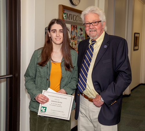 Two people standing together, smiling: Award winner Amanda Moyer and Professor George Searles