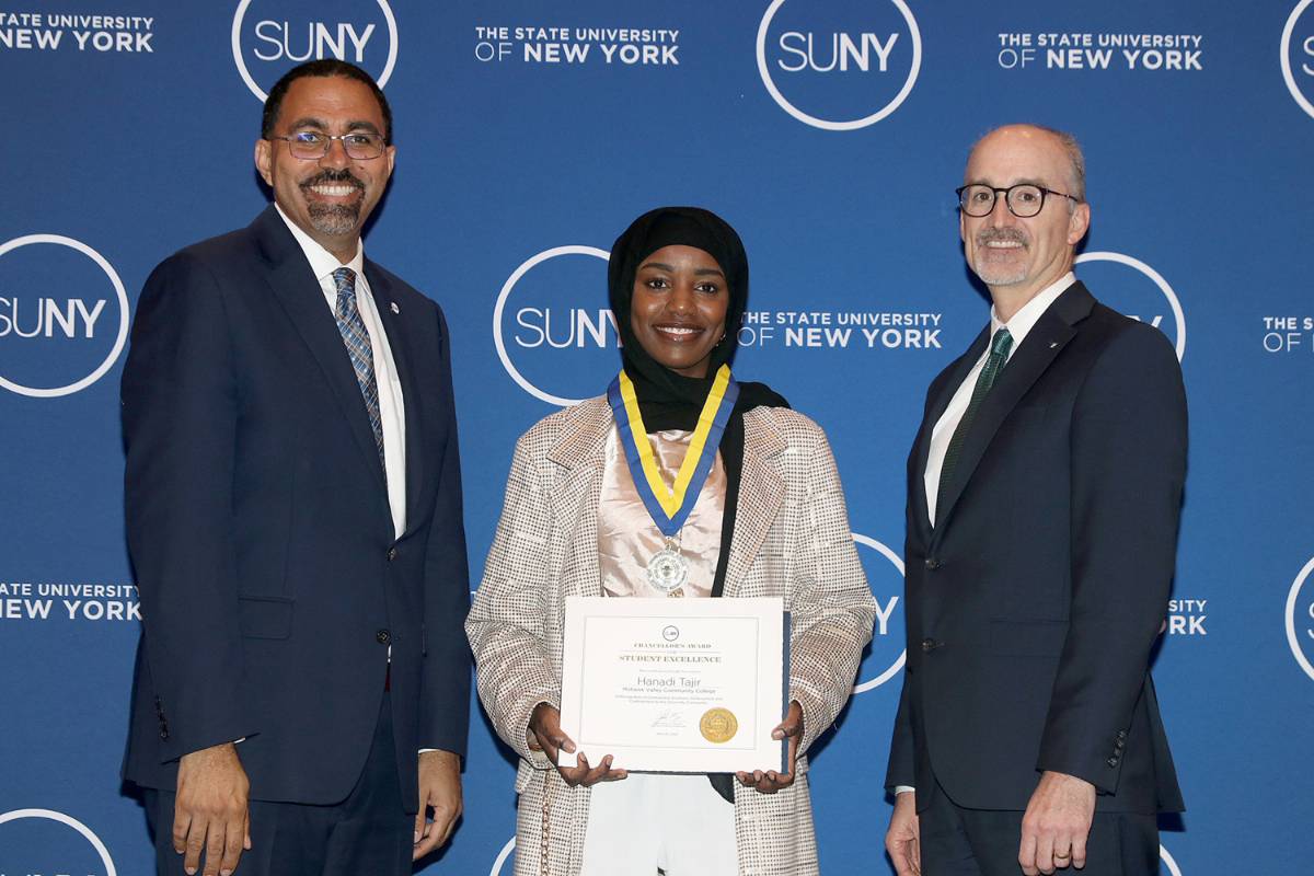 Image of three people standing in front of blue background with SUNY logo: SUNY Chancellor John King, MVCC student Hanadi Tajir holding certificate, MVCC President Randall VanWagoner