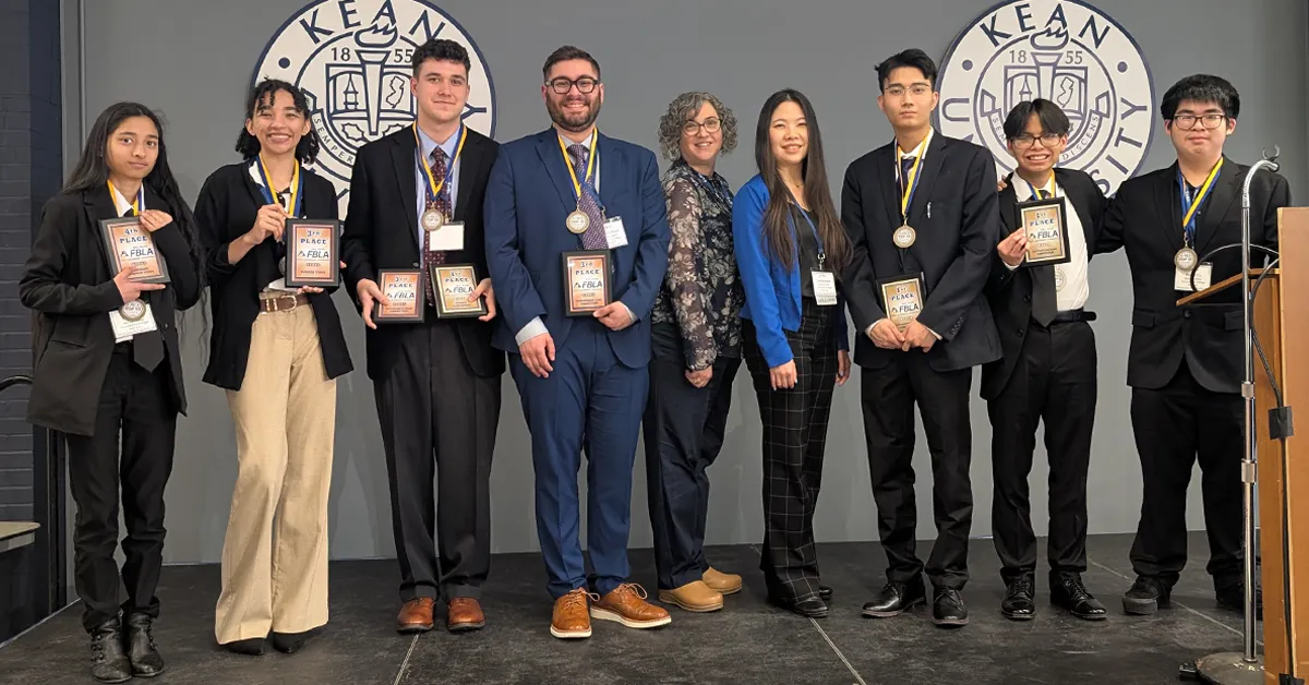 MVCC FBLA students and advisors stand on a stage holding awards