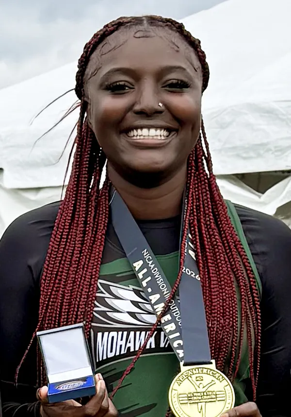 Person wearing sports medals, smiling