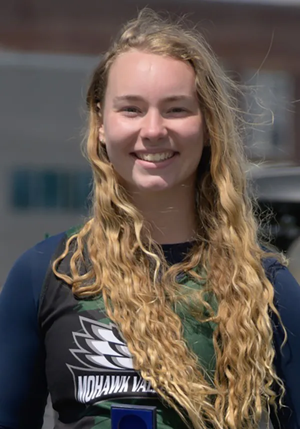 Person wearing sports medals, smiling
