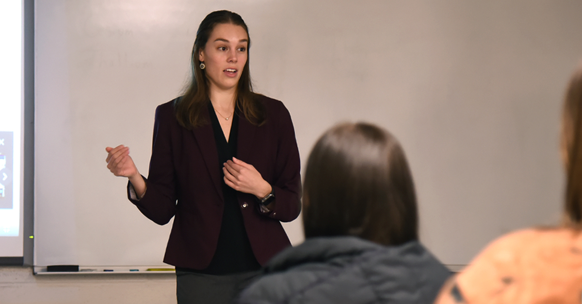 Alexis Race standing at front of classroom, talking to students