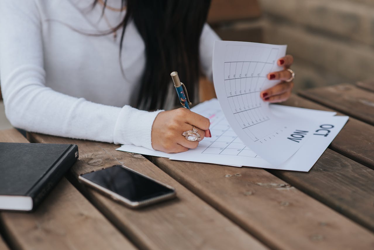 image of woman writing on a desk calendar