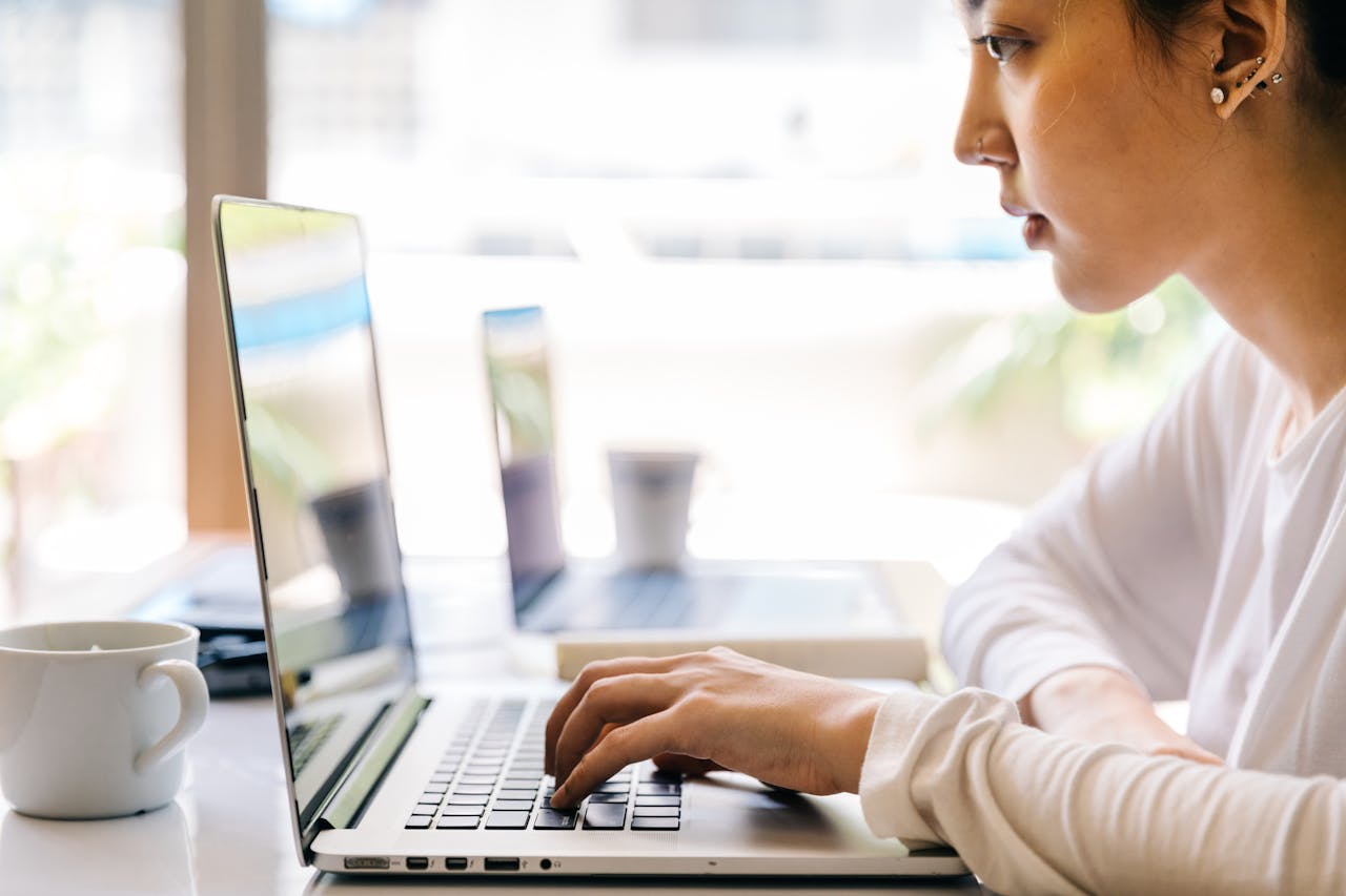 image of woman sitting at a table with a laptop